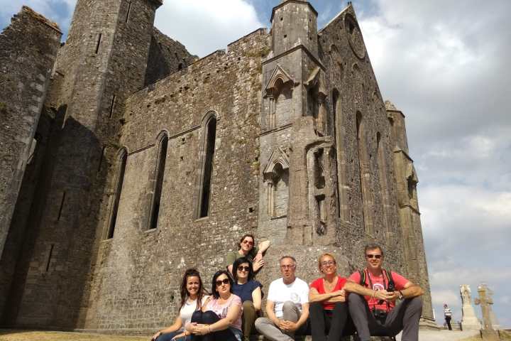 grupo de gente sentado delante de un castillo