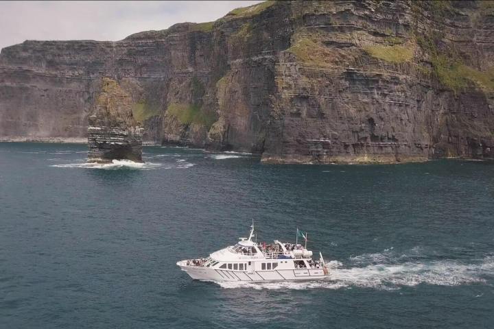 a small boat in a body of water with a mountain in the background
