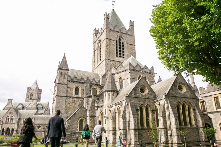 a group of people standing in front of a church with Christ Church Cathedral, Dublin in the background
